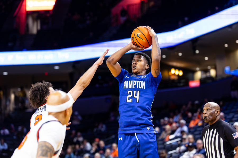 Basketball player in blue jersey with 'Hampton' and number 24 taking a shot during a game.