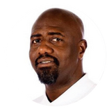 Headshot of Ivan Thomas facing the camera against a light background.