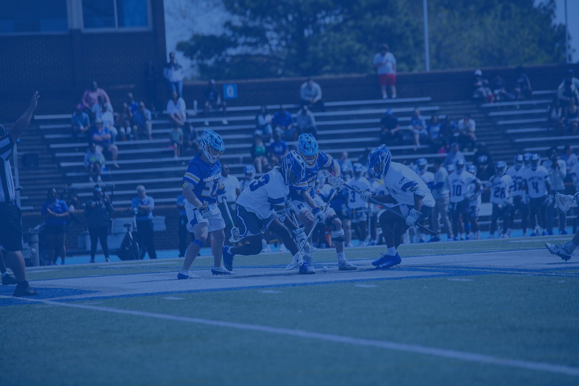 Lacrosse game in progress with players on the field