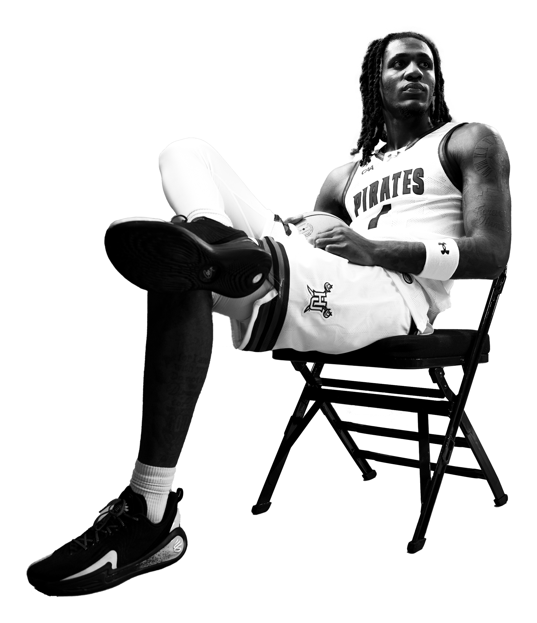 Black-and-white photo of a Hampton student-athlete sitting in a chair, wearing a sports jersey with visible HU branding.