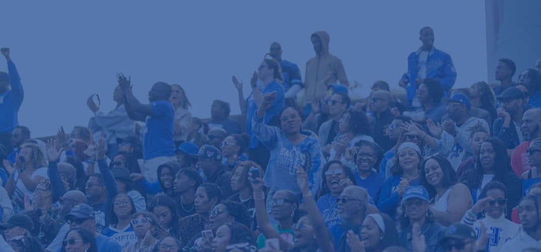 A crowd of people cheering in stadium seating, heavily tinted in blue tones.