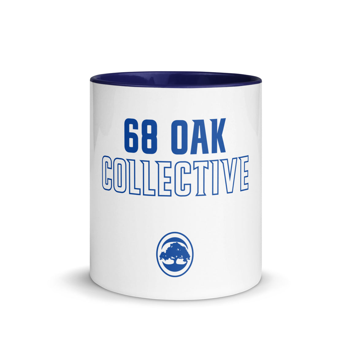White ceramic mug with blue interior and text '68 Oak Collective.' 